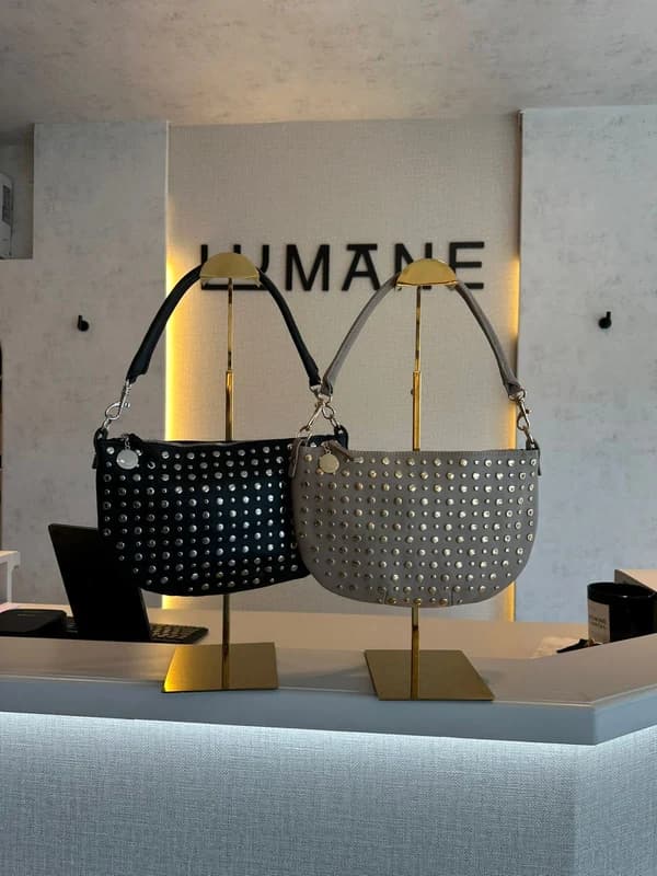 Bolso de piel negra con tachuelas y herrajes plateados.